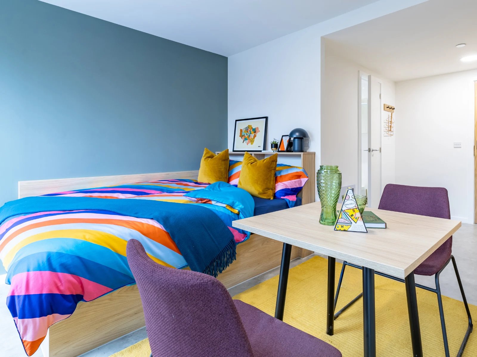 Bed with colorful bedding table chairs and vase bedroom at Venti House in London Student Accommodation