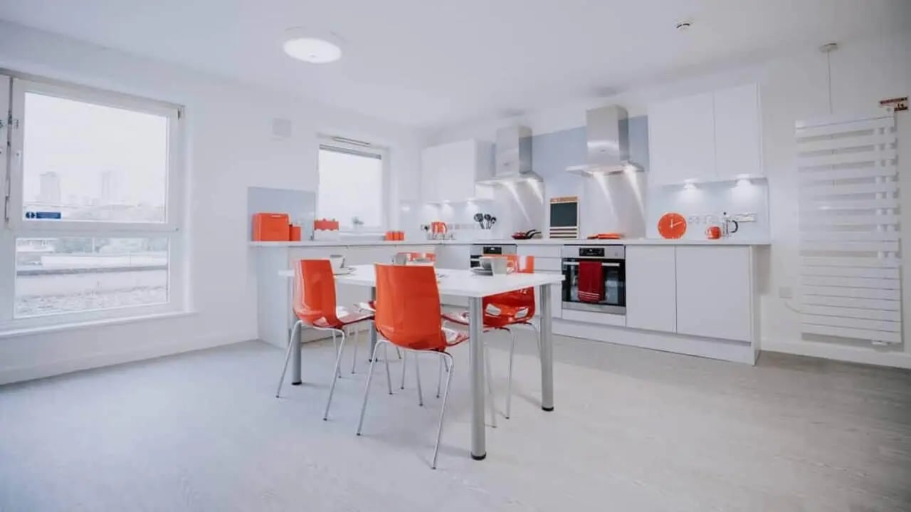 White table orange chairs modern kitchen with oven at Manna Ash House in London Student Accommodation