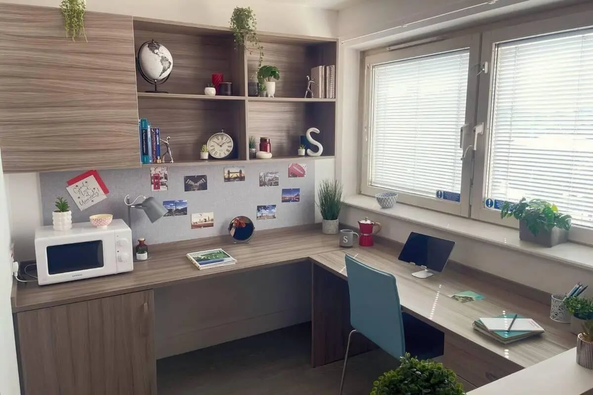 Desk with microwave and laptop study area at Manna Ash House in London Student Accommodation