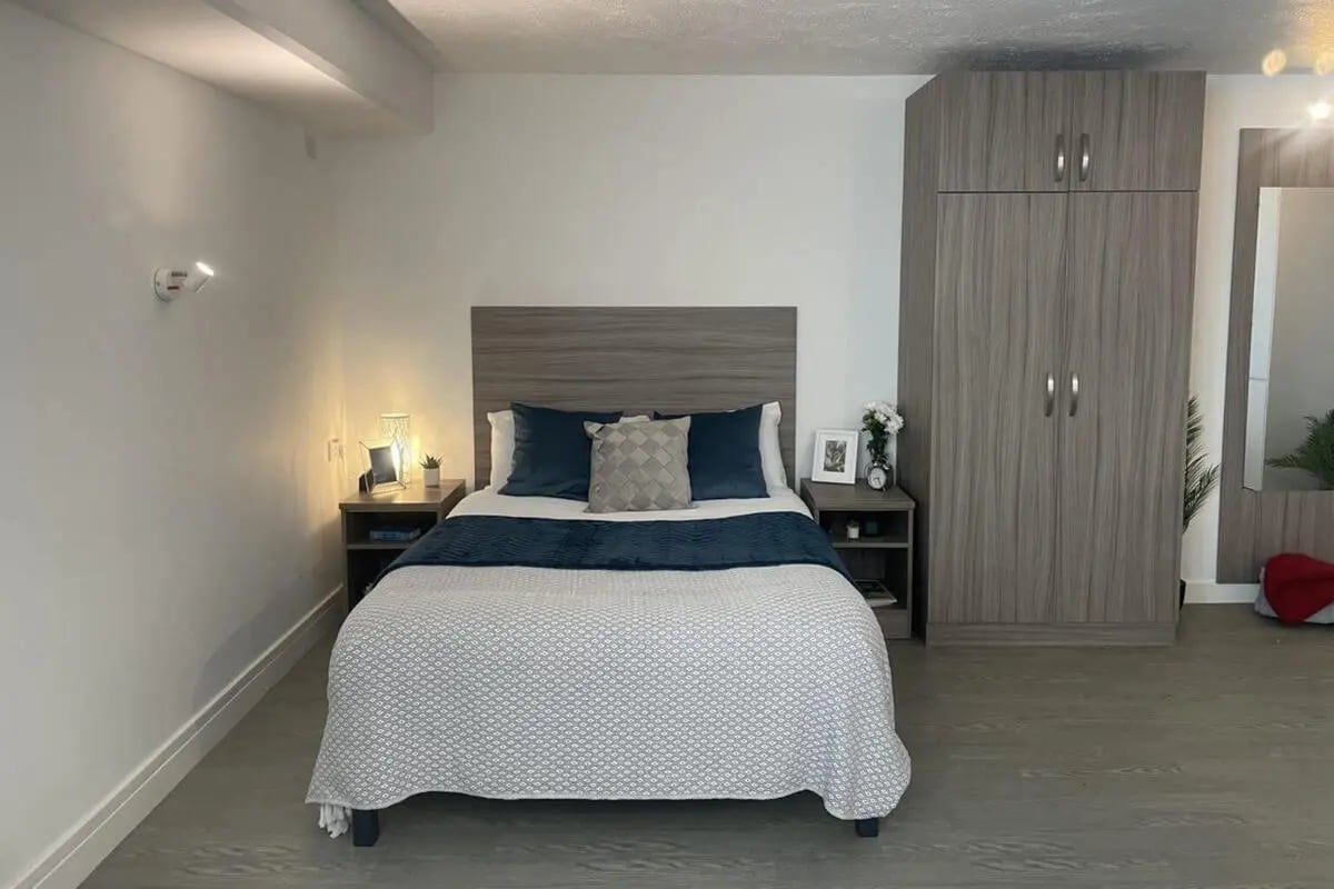 Bed nightstands lamp wardrobe bedroom at Manna Ash House in London Student Accommodation