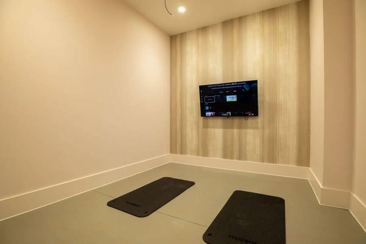 Two yoga mats and a television playing Image Type Recreation Room at Yugo Crown Place in Birmingham Student Accommodation