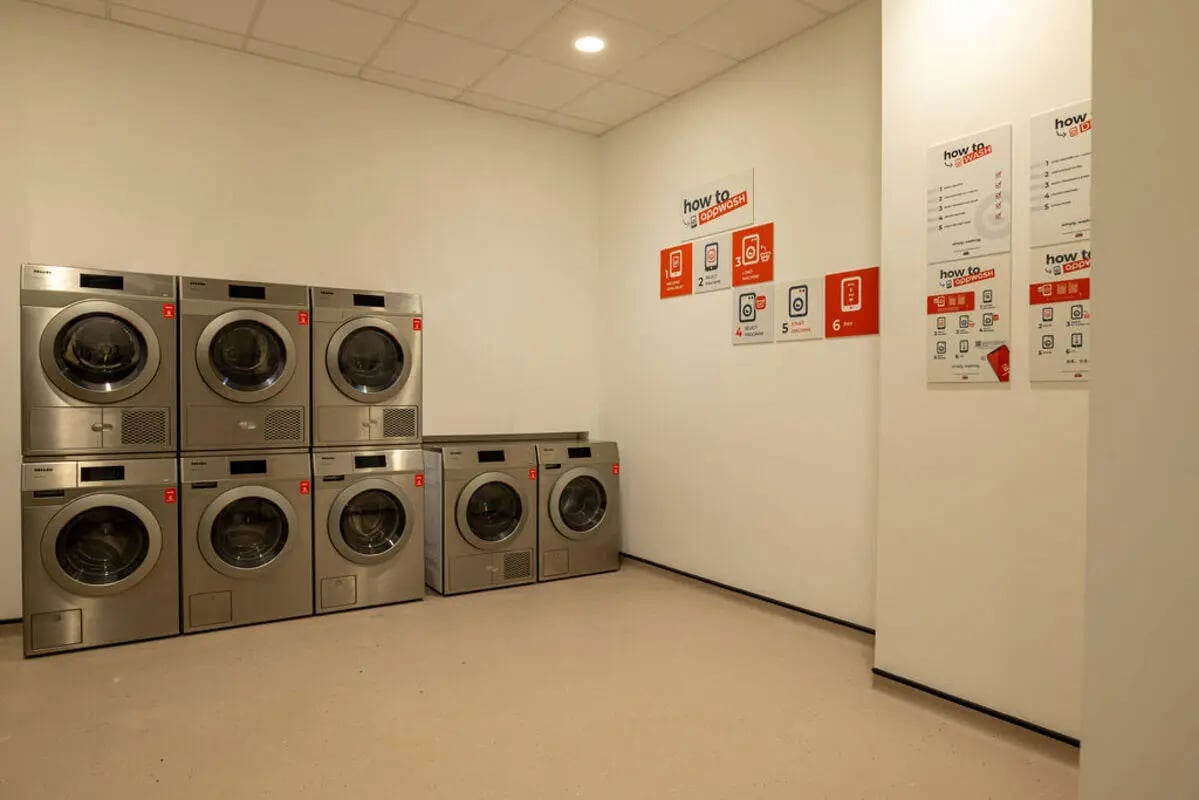 Washing machines and dryers stacked in rows laundry room at Yugo Crown Place in Birmingham Student Accommodation