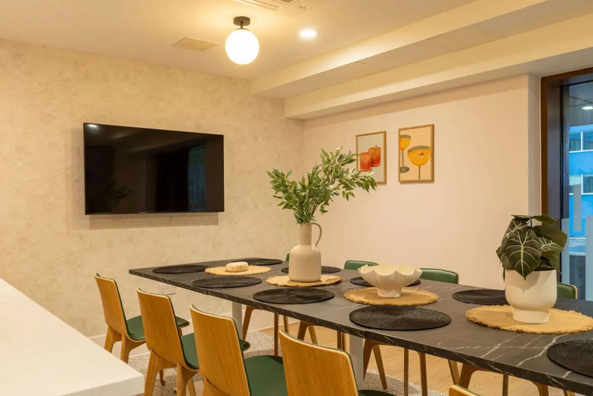 Dining table chairs television artwork plants dining area at Yugo Crown Place in Birmingham Student Accommodation
