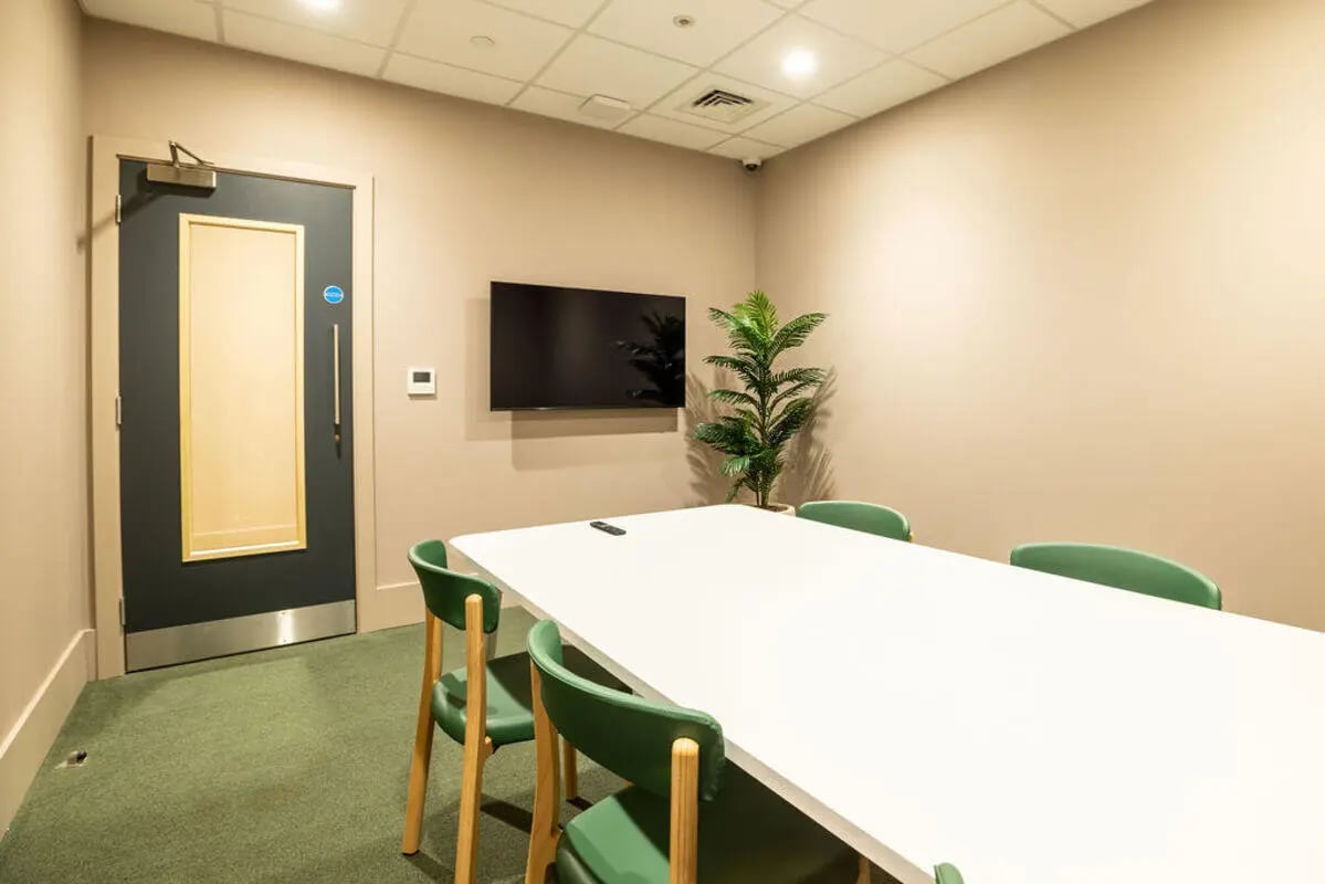 Table chairs TV plant room meeting room at Yugo Crown Place in Birmingham Student Accommodation