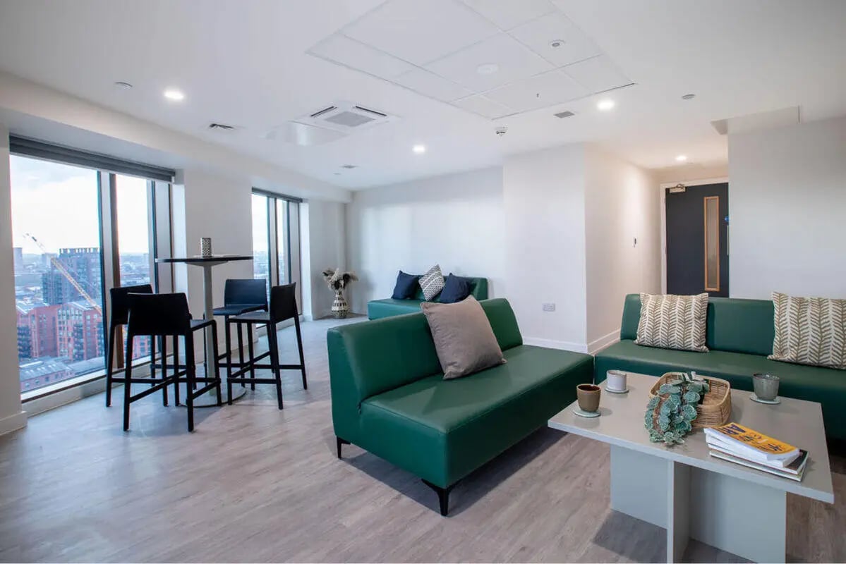 Green sofas bar stools and table living room at Yugo Crown Place in Birmingham Student Accommodation