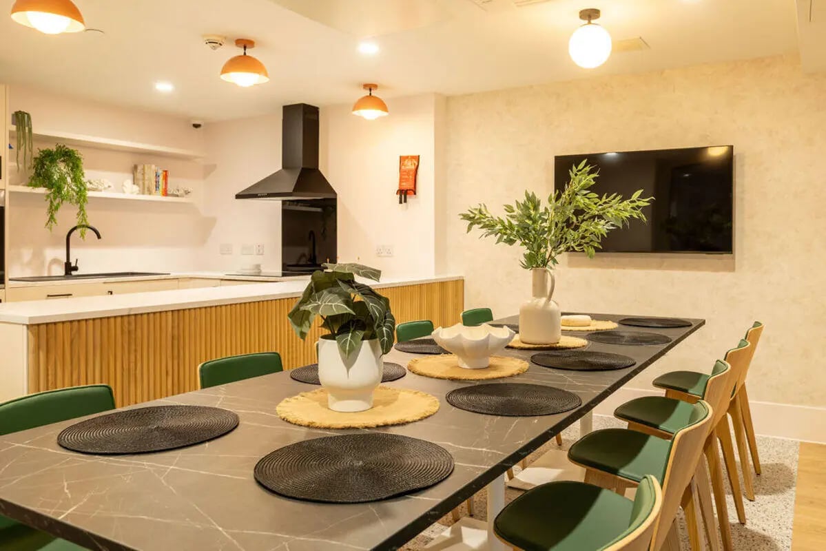 Dining table with green chairs kitchen area at Yugo Crown Place in Birmingham Student Accommodation