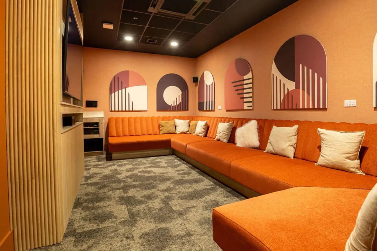 Orange sectional sofa with pillows living room at Yugo Crown Place in Birmingham Student Accommodation