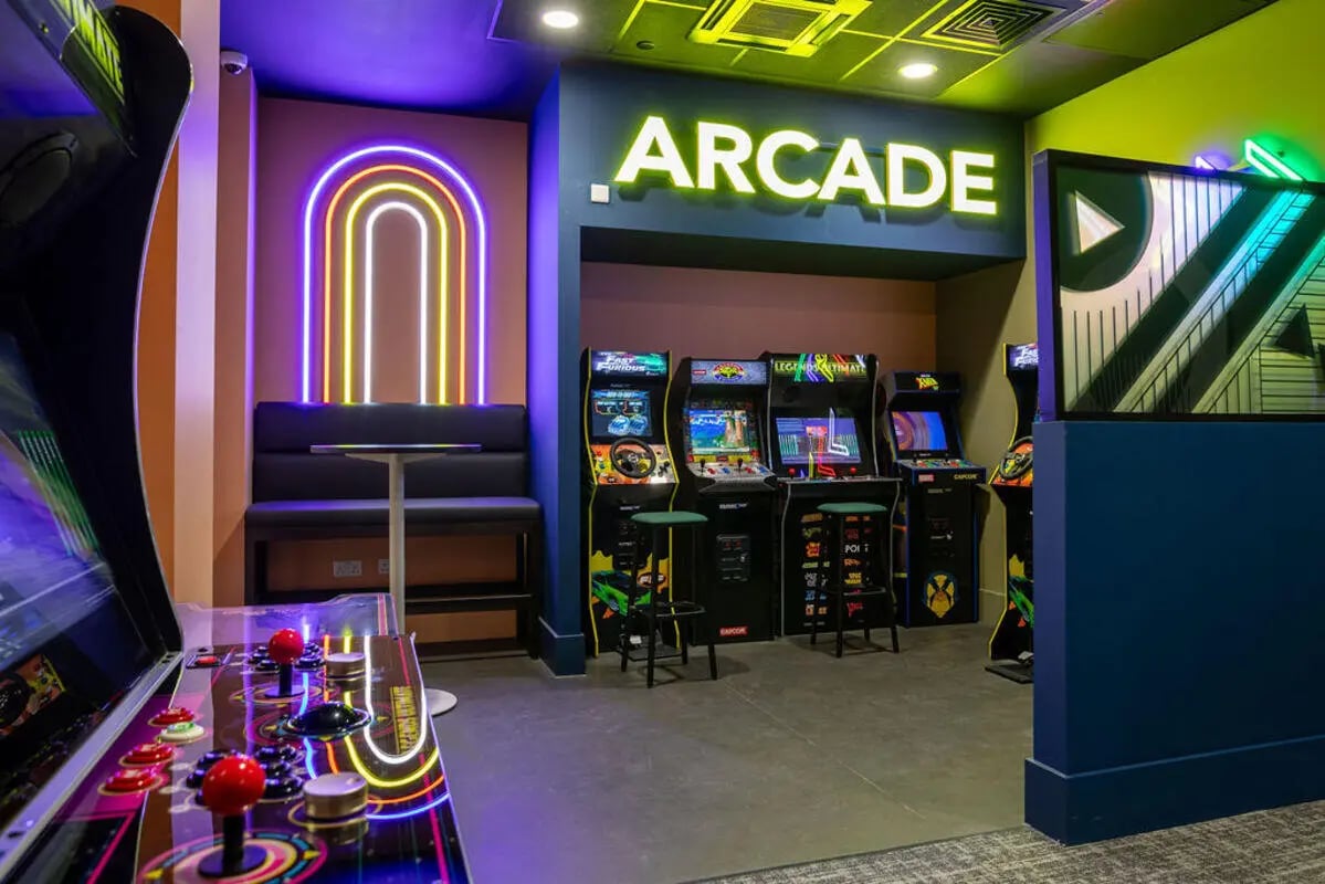 Arcade machines neon lights seating playing area at Yugo Crown Place in Birmingham Student Accommodation