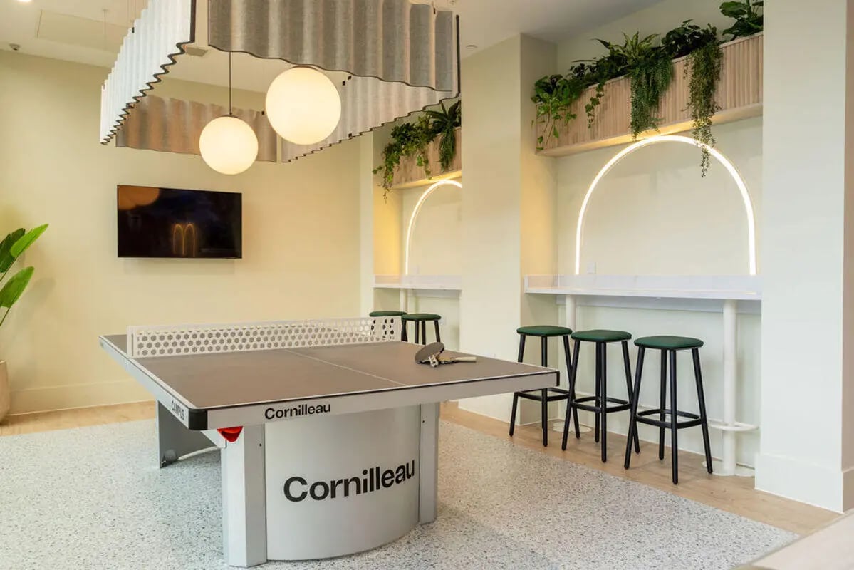 Ping pong table bar stools and plants recreation room at Yugo Crown Place in Birmingham Student Accommodation