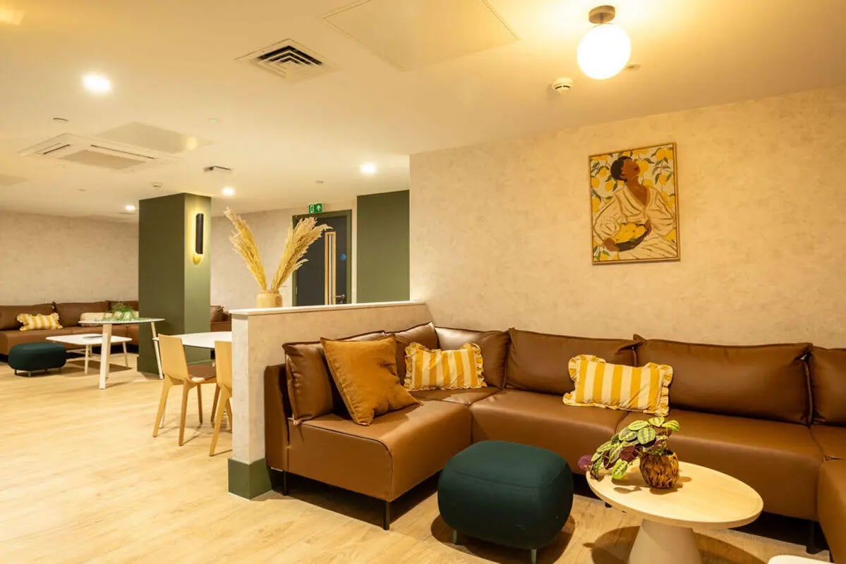 Brown sectional sofa with yellow pillows living room at Yugo Crown Place in Birmingham Student Accommodation