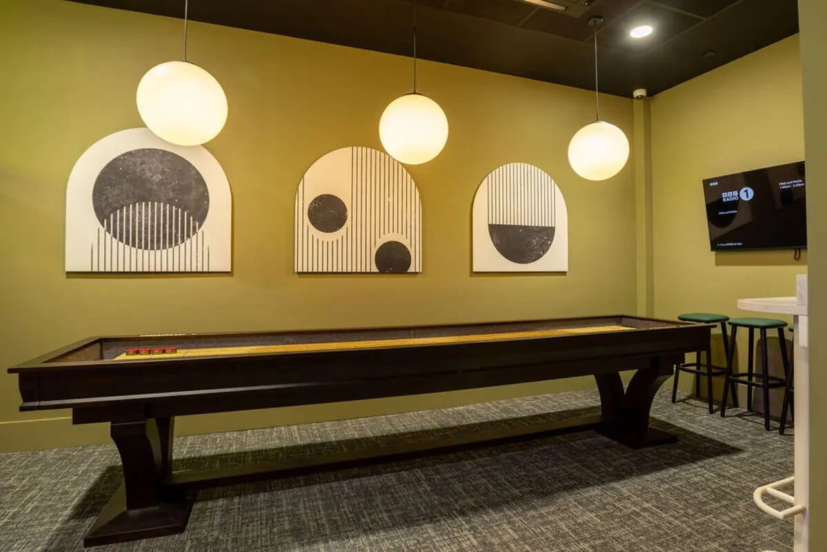 Shuffleboard table modern art and stools common area at Yugo Crown Place in Birmingham Student Accommodation