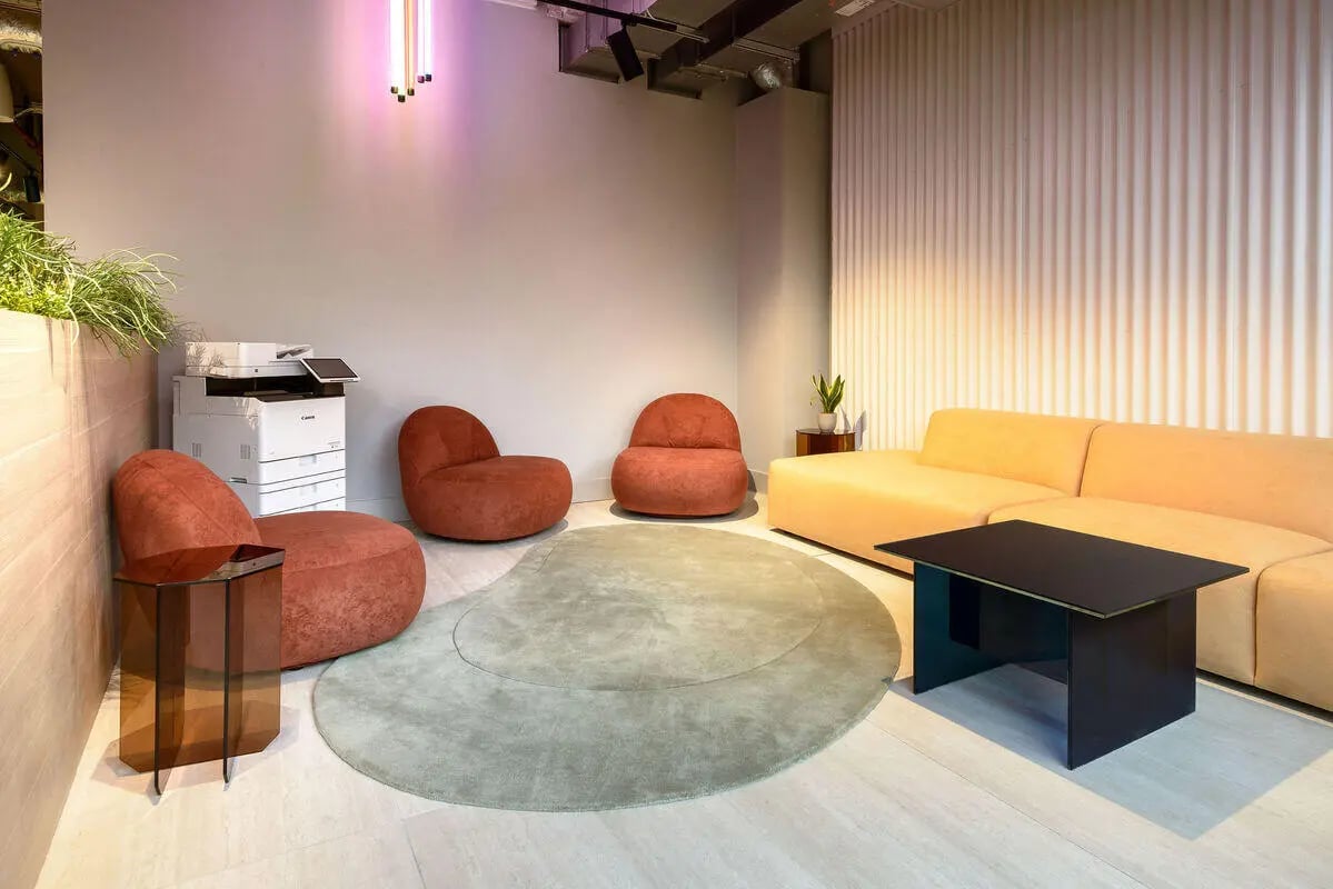Printer chairs sofa rug and table lounge area at True Nottingham in Nottingham Student Accommodation
