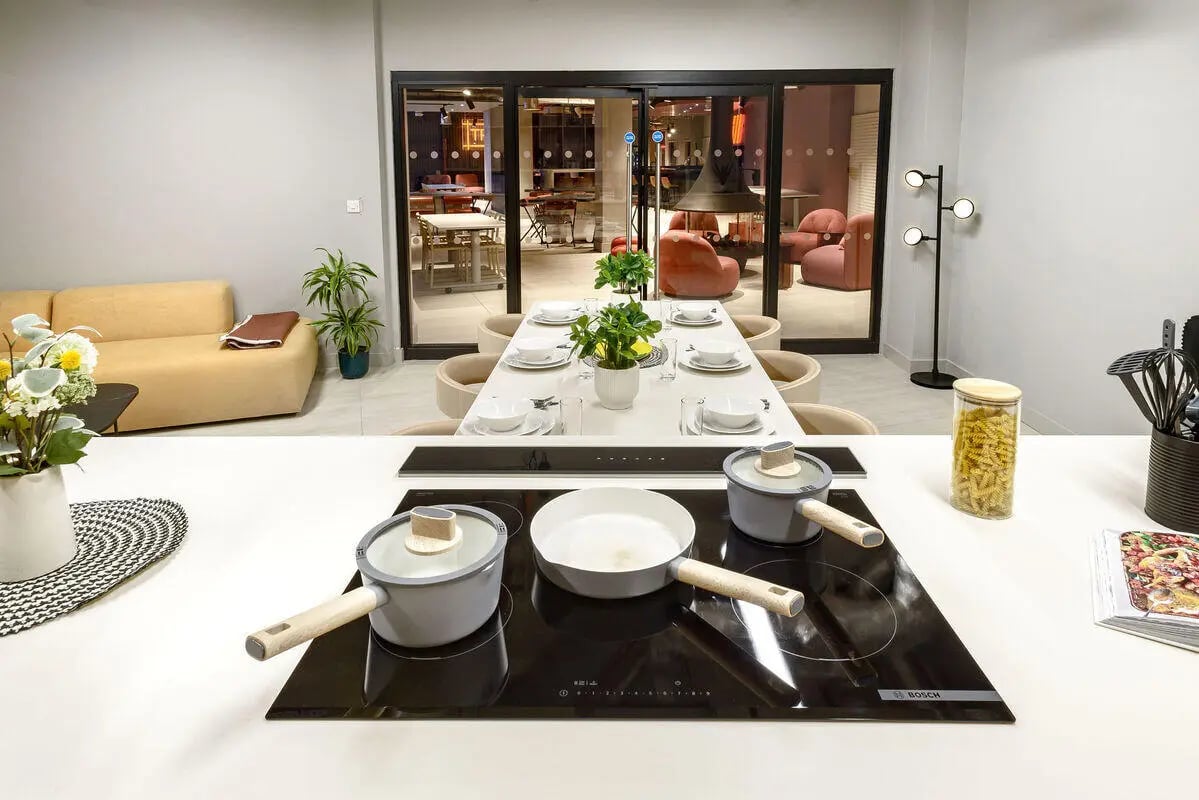 Pots on stove dining table and sofa kitchen at True Nottingham in Nottingham Student Accommodation