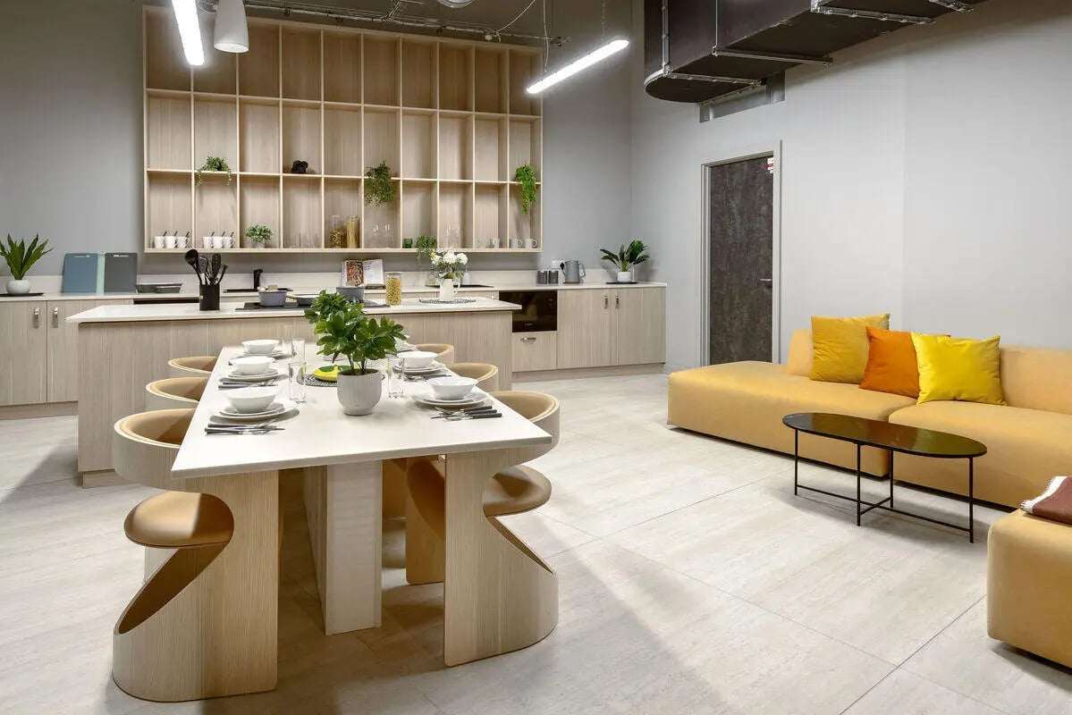 Dining table kitchen area and yellow sofa living room at True Nottingham in Nottingham Student Accommodation