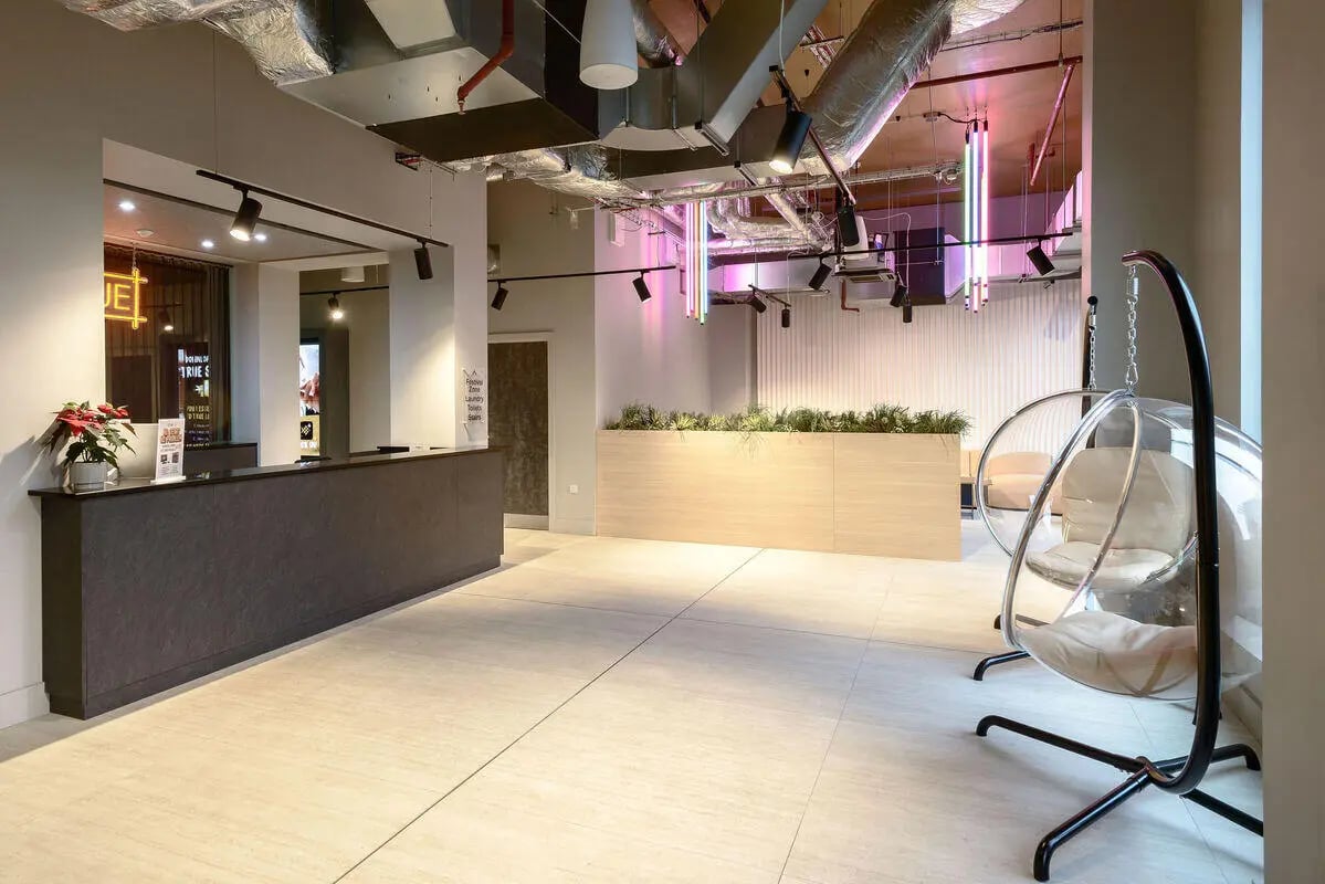 Reception desk plant bubble chairs communal area at True Nottingham in Nottingham Student Accommodation