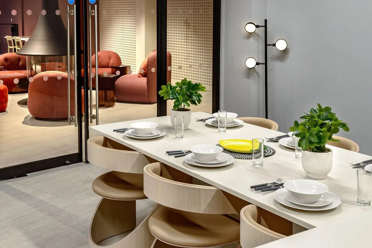 Dining table setting with chairs plants and seating area at True Nottingham in Nottingham Student Accommodation