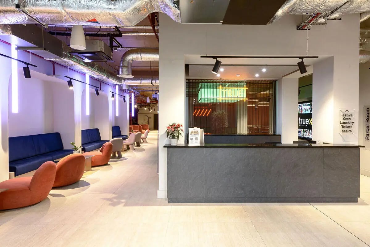Reception area with seating and counter reception area at True Nottingham in Nottingham Student Accommodation