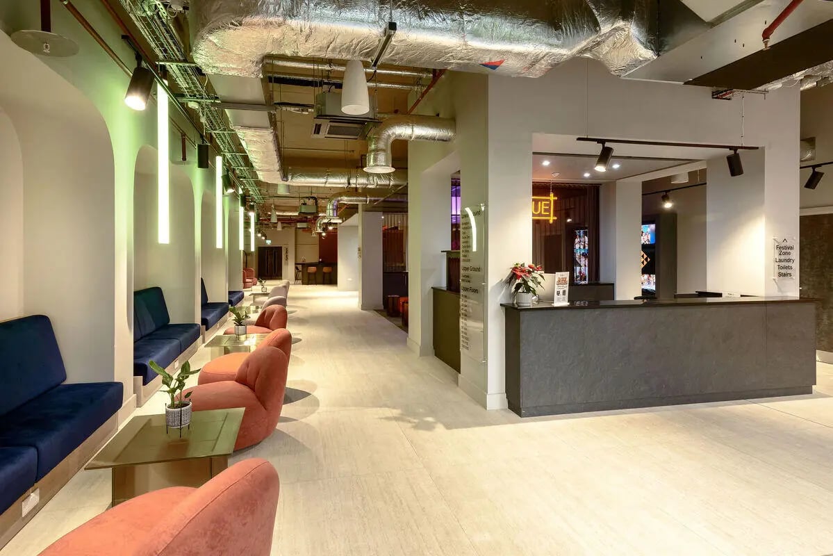 Blue and coral seating with glass tables reception lobby at True Nottingham in Nottingham Student Accommodation