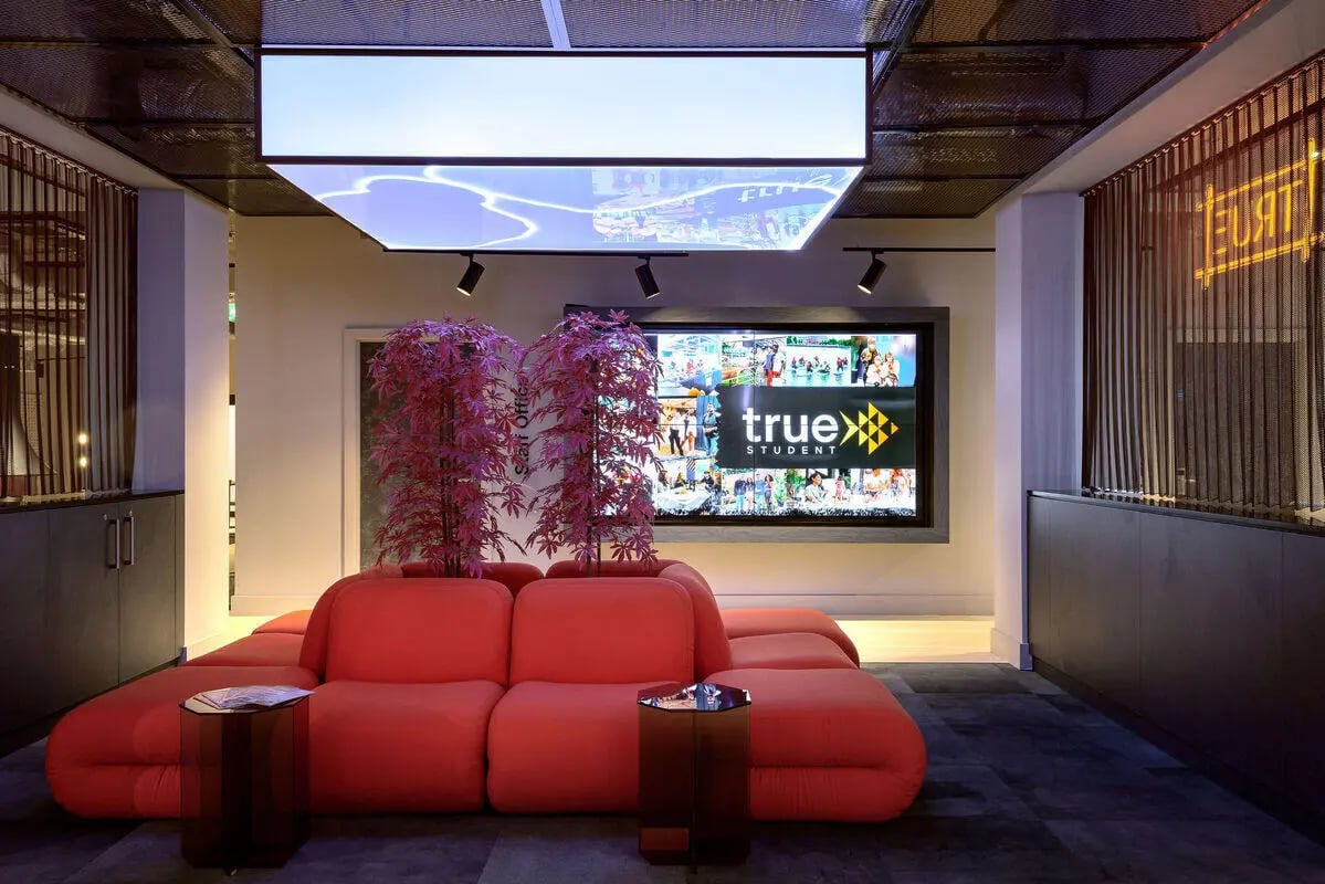 Red sectional couch with large screen living room at True Nottingham in Nottingham Student Accommodation