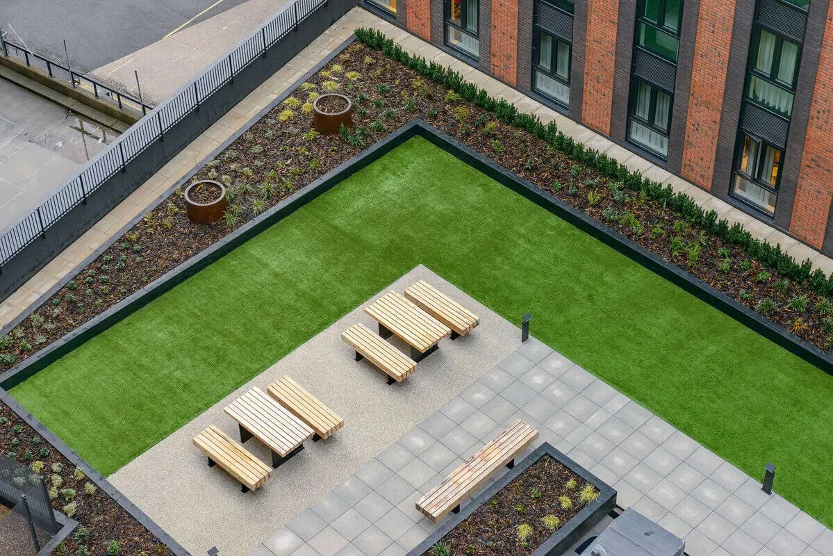 Picnic tables and benches on rooftop amenity area at True Nottingham in Nottingham Student Accommodation