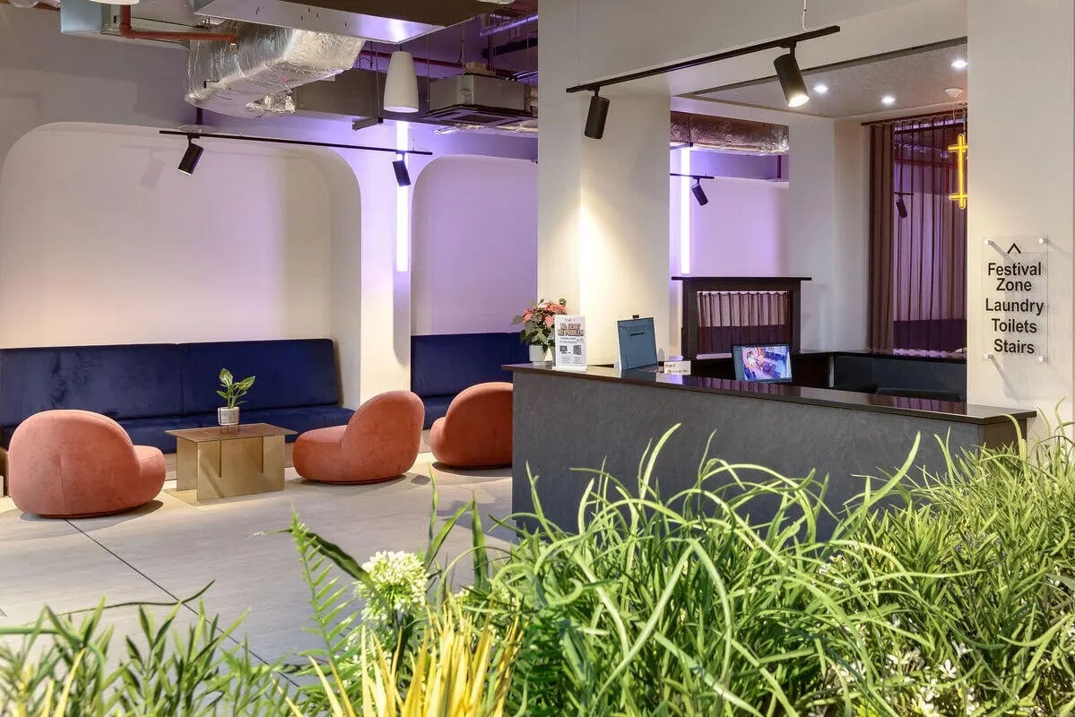 Blue sofa coral chairs reception desk living room at True Nottingham in Nottingham Student Accommodation