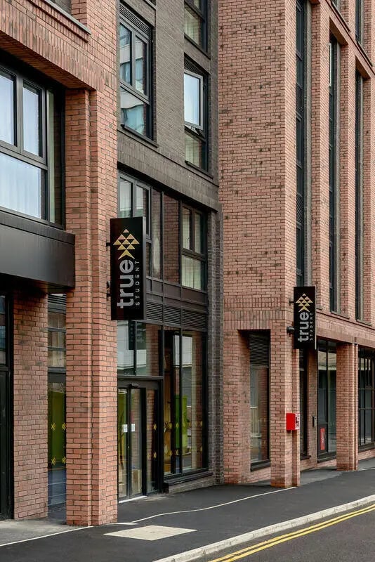 Modern brick building with signage exterior at True Nottingham in Nottingham Student Accommodation
