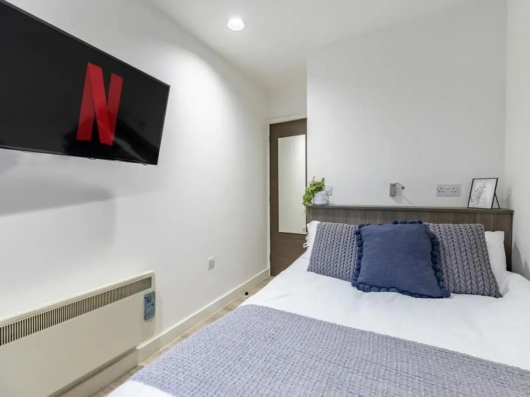 Netflix TV over bed with pillows and radiator Bedroom at Centre Gate in Bristol Student Accommodation
