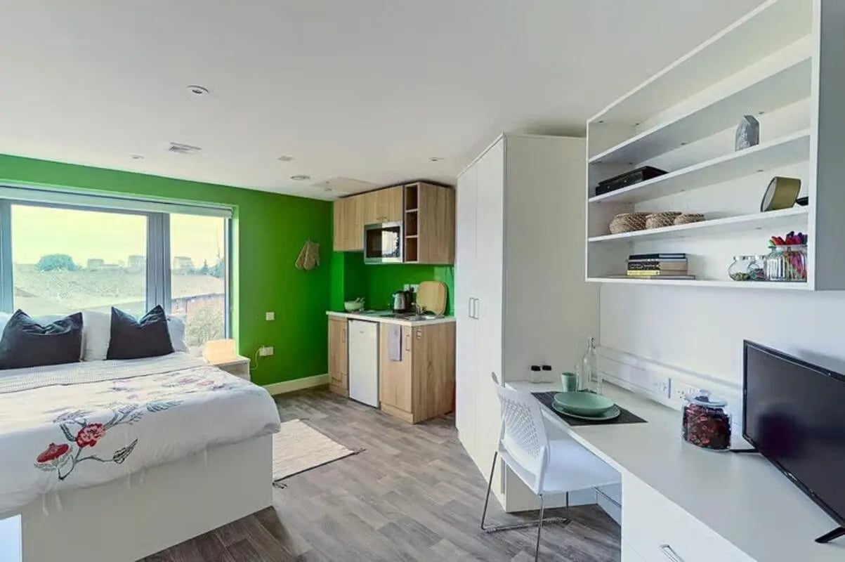 Bed kitchen desk and shelves student studio at The Cube Greenwich in London Student Accommodation