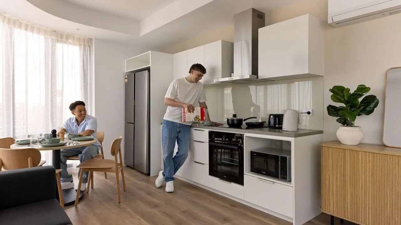 Two men in a modern kitchen and dining area at UniLodge Perth Central in Perth Student Accommodation