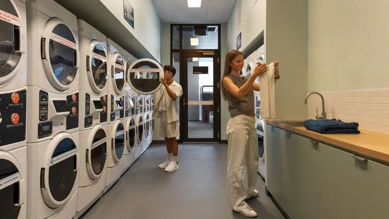 Students near dryers and sink laundry room at UniLodge Perth Central in Perth Student Accommodation