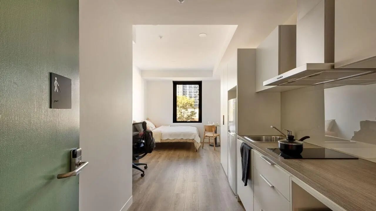 Bed desk chair kitchen counter with stove bedroom kitchen at UniLodge Perth Central in Perth Student Accommodation