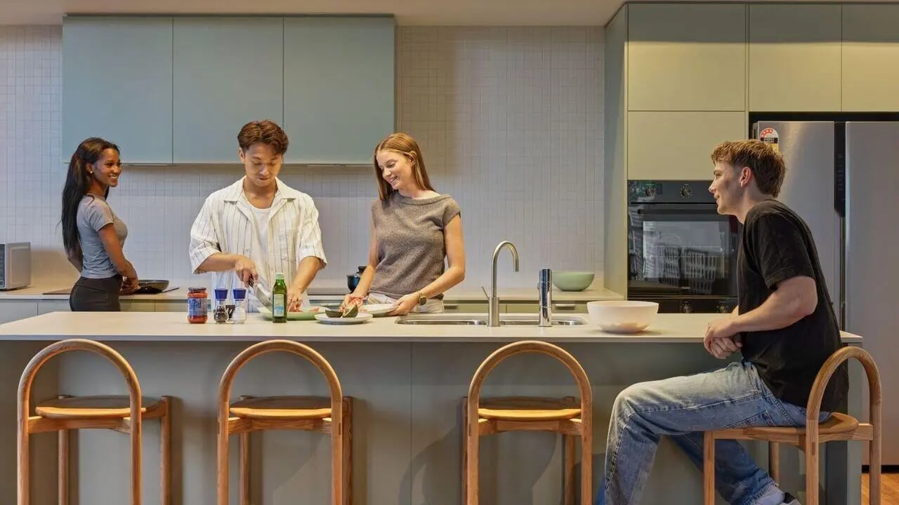 Four people cooking and socializing at island kitchen at UniLodge Perth Central in Perth Student Accommodation