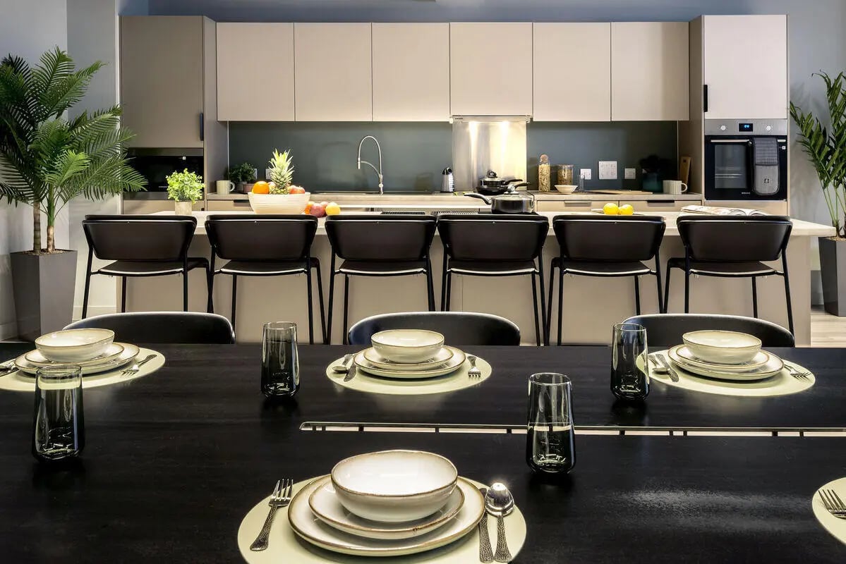 Dining table with place settings and modern kitchen exterior at True Leicester in Leicester Student Accommodation
