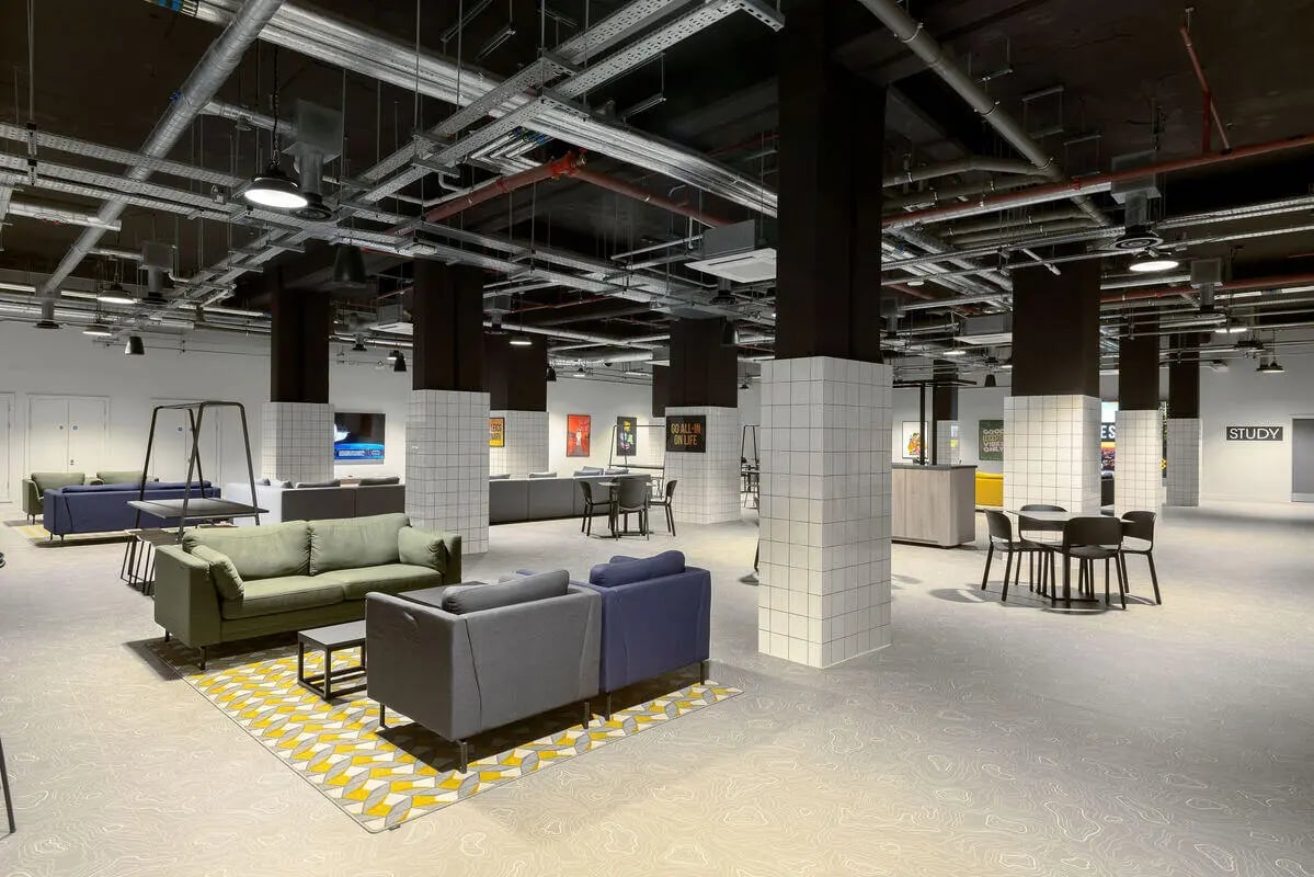 Sofa and tables with chairs lounge area at True Leicester in Leicester Student Accommodation