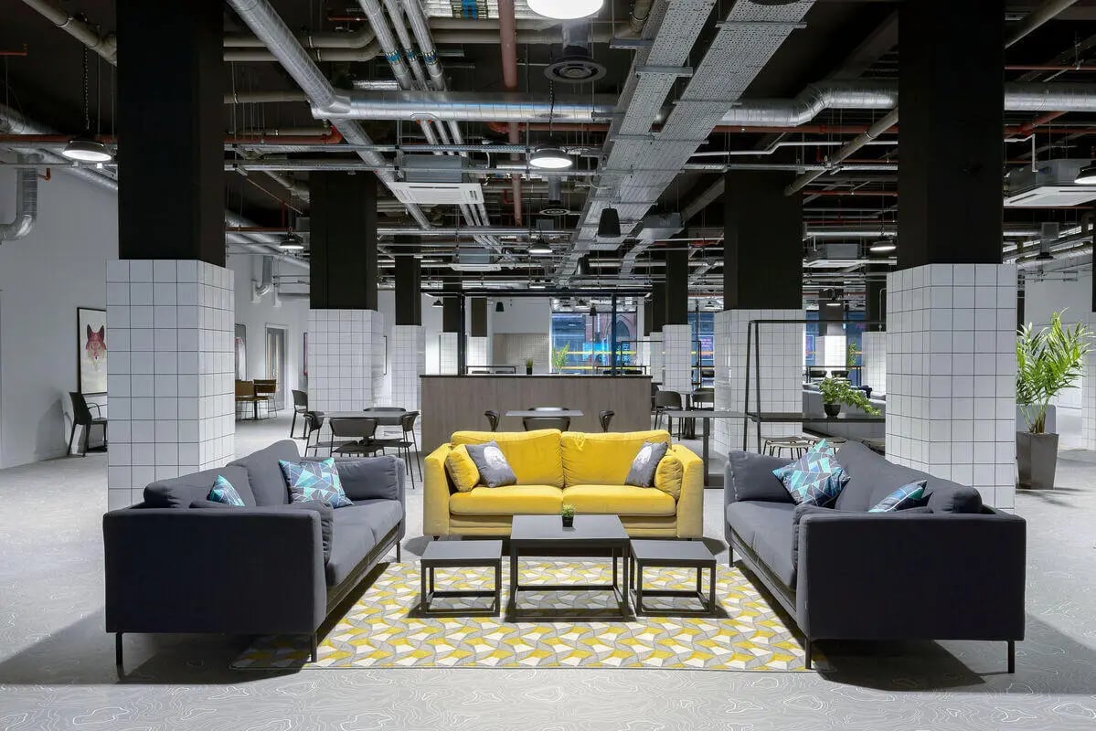 Gray and yellow sofas with patterned rug communal area at True Leicester in Leicester Student Accommodation