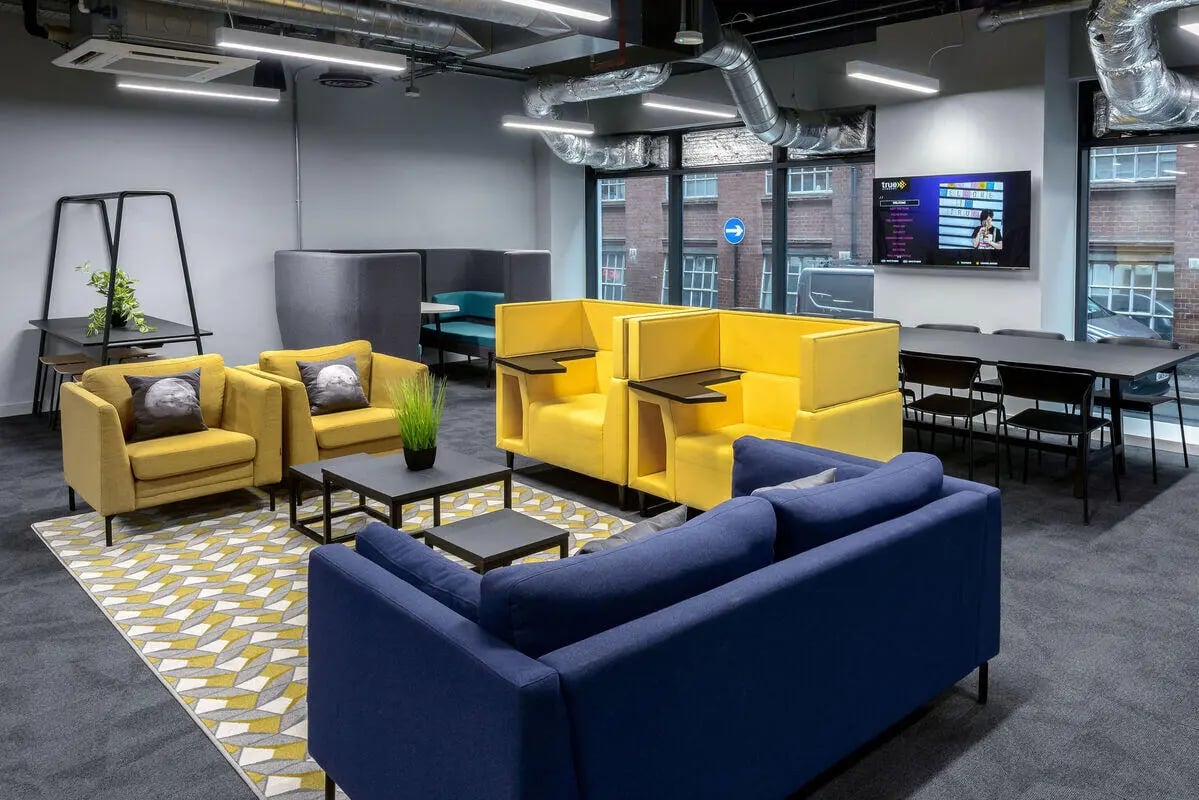 Yellow and blue sofas table and chairs lounge area at True Leicester in Leicester Student Accommodation