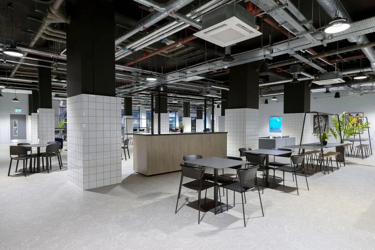 Modern seating area with tables and chairs common area at True Leicester in Leicester Student Accommodation