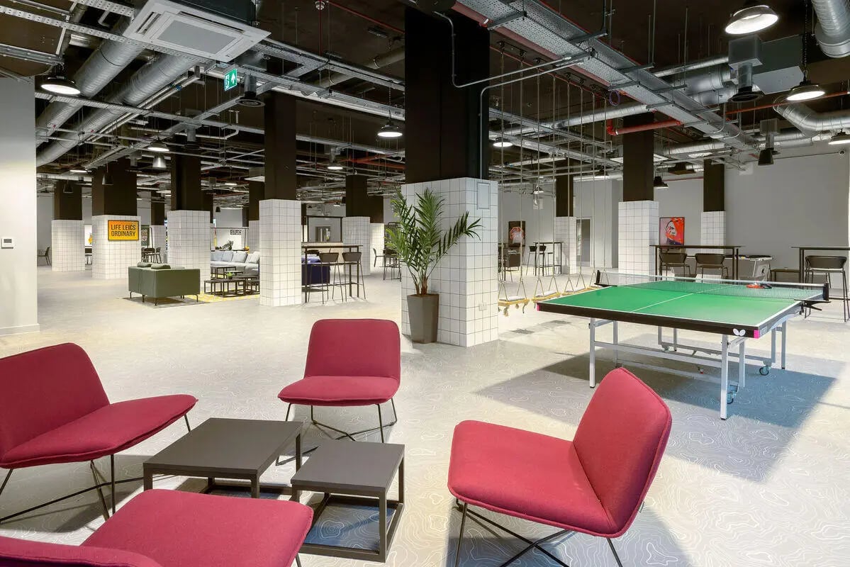 Red chairs ping pong table and seating area common room at True Leicester in Leicester Student Accommodation