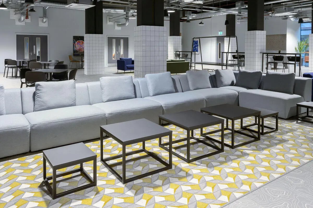 Light grey sectional sofa coffee tables geometric rug common area at True Leicester in Leicester Student Accommodation