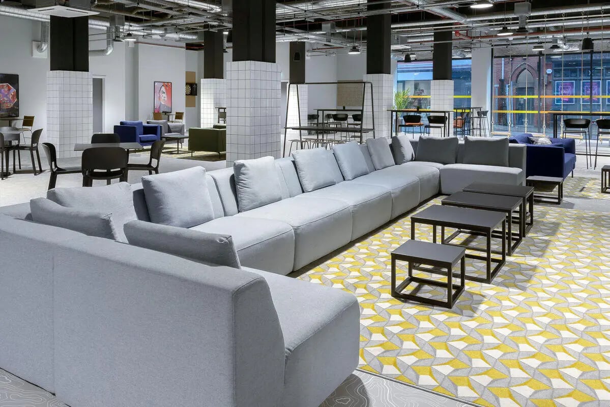 Modern common room with grey sofas and tables Living room at True Leicester in Leicester Student Accommodation