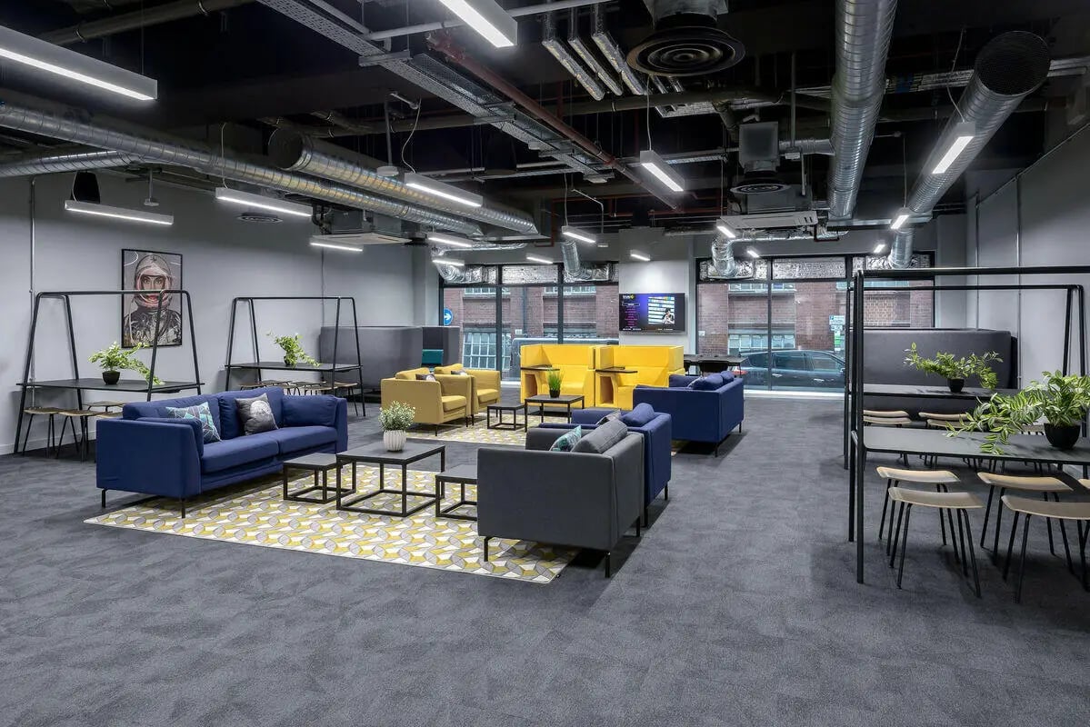 Modern communal lounge with blue sofas yellow chairs living room at True Leicester in Leicester Student Accommodation
