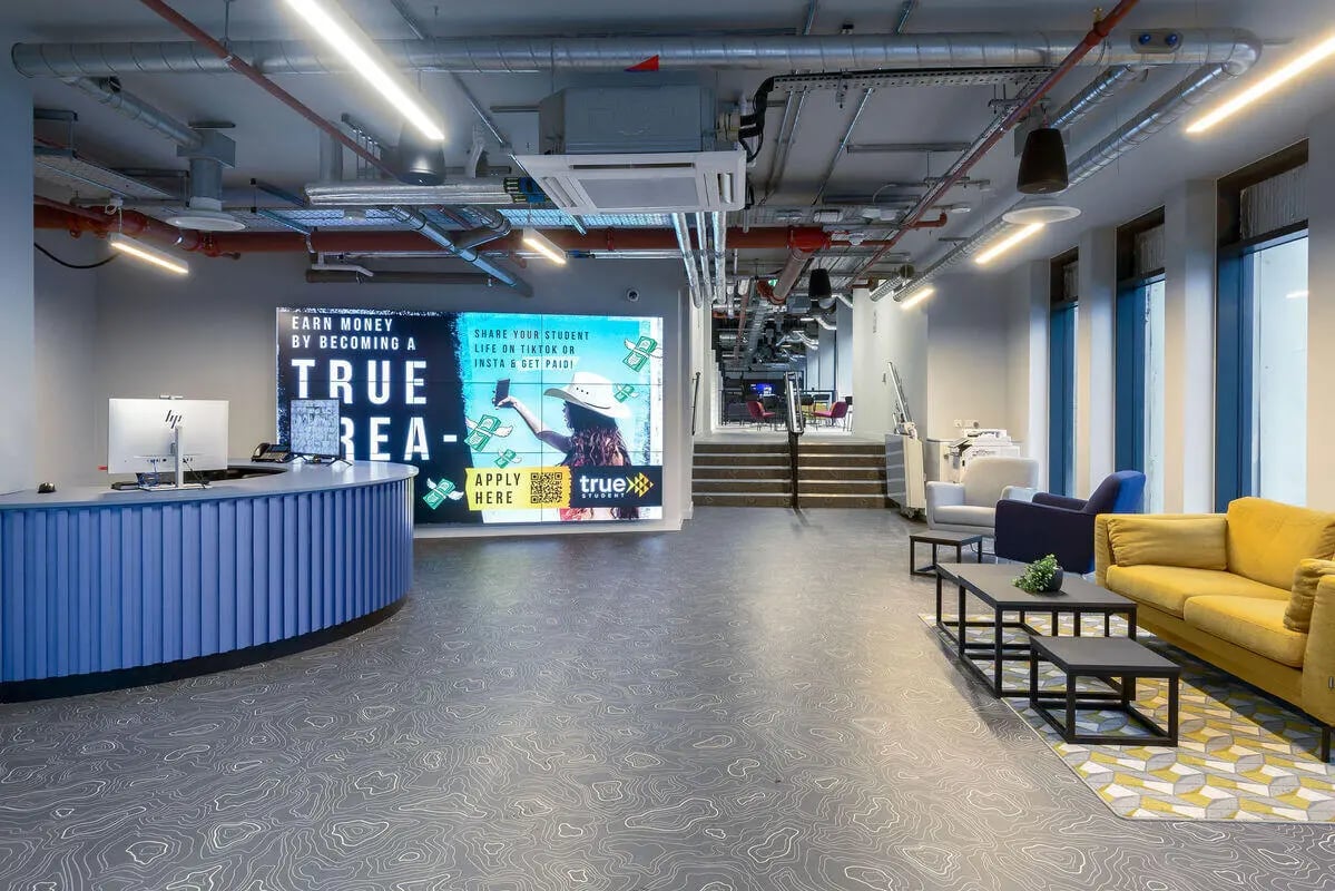 Reception desk digital screen lounge seating living room at True Leicester in Leicester Student Accommodation