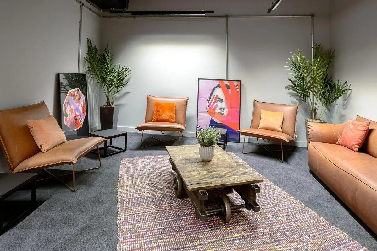 Brown chairs table artwork plants living room at True Leicester in Leicester Student Accommodation