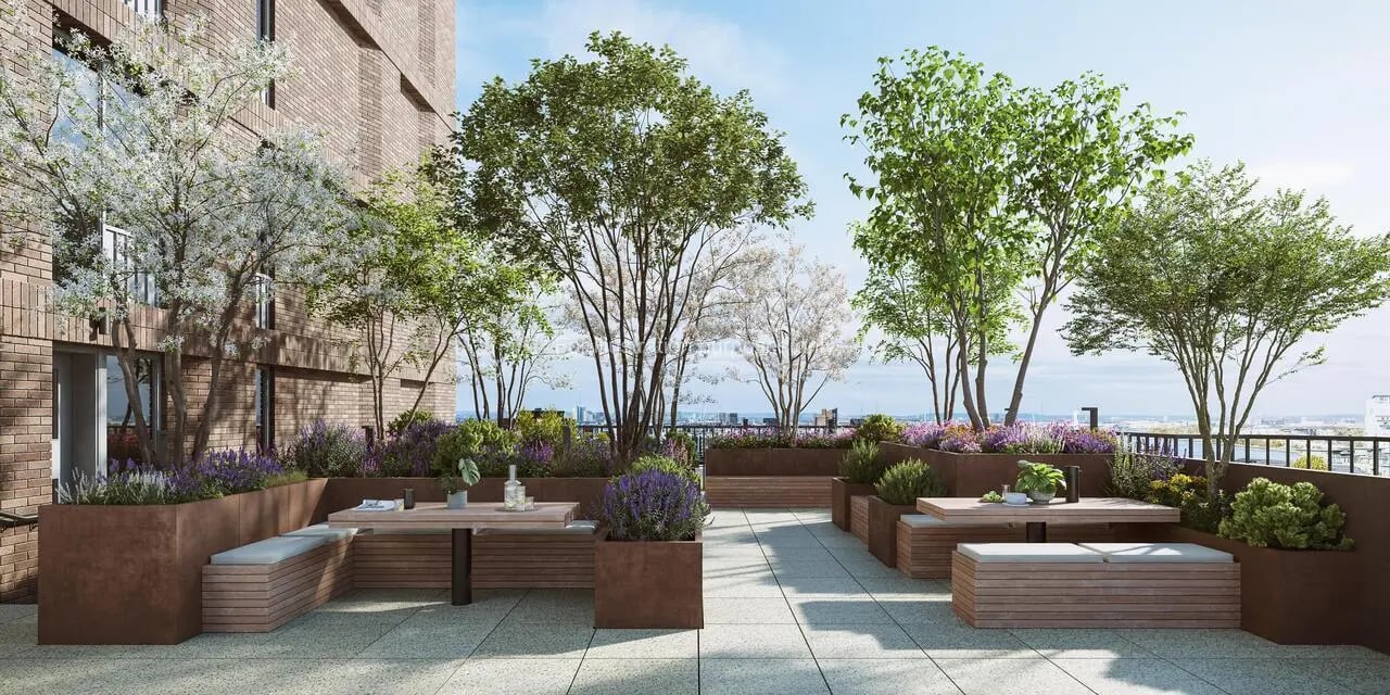Outdoor seating area with tables benches plants exterior at Press House in London Student Accommodation