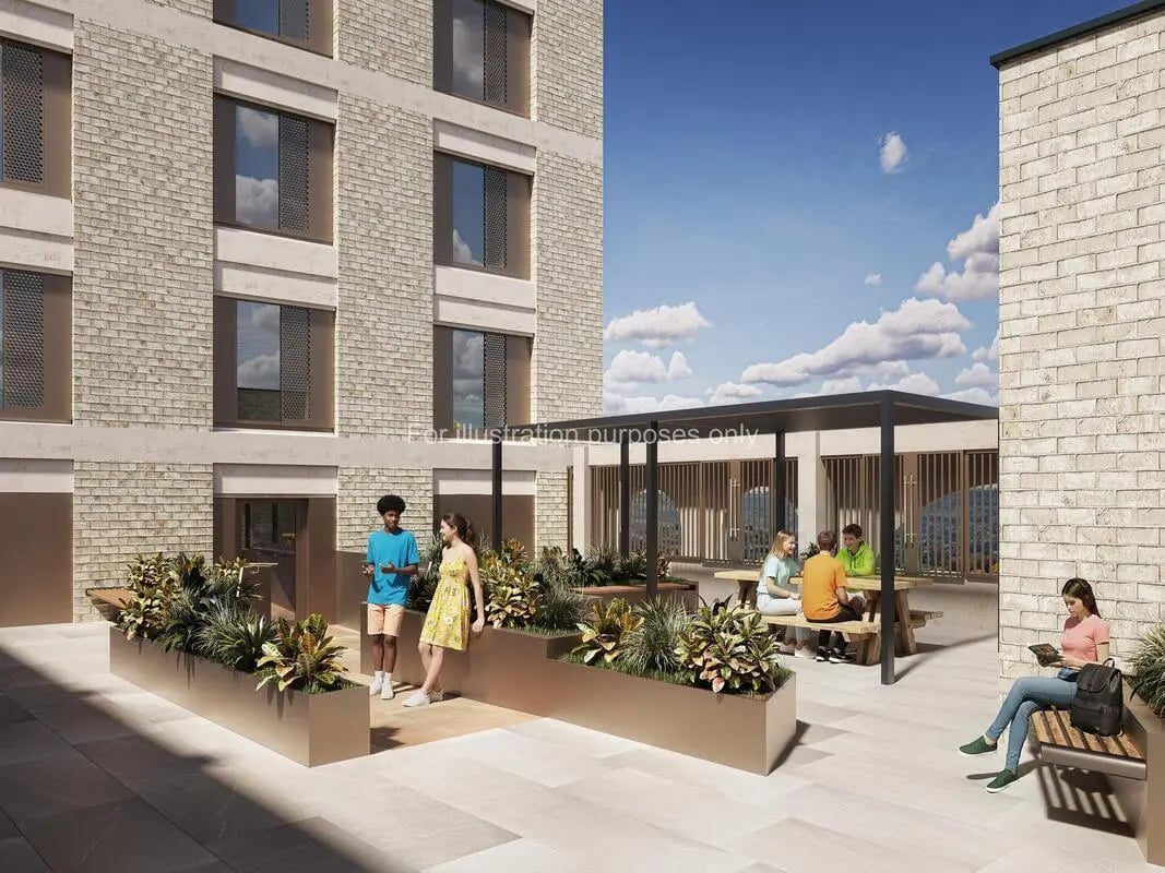 People sitting at picnic tables and bench courtyard exterior at Timber Yard in Bristol Student Accommodation