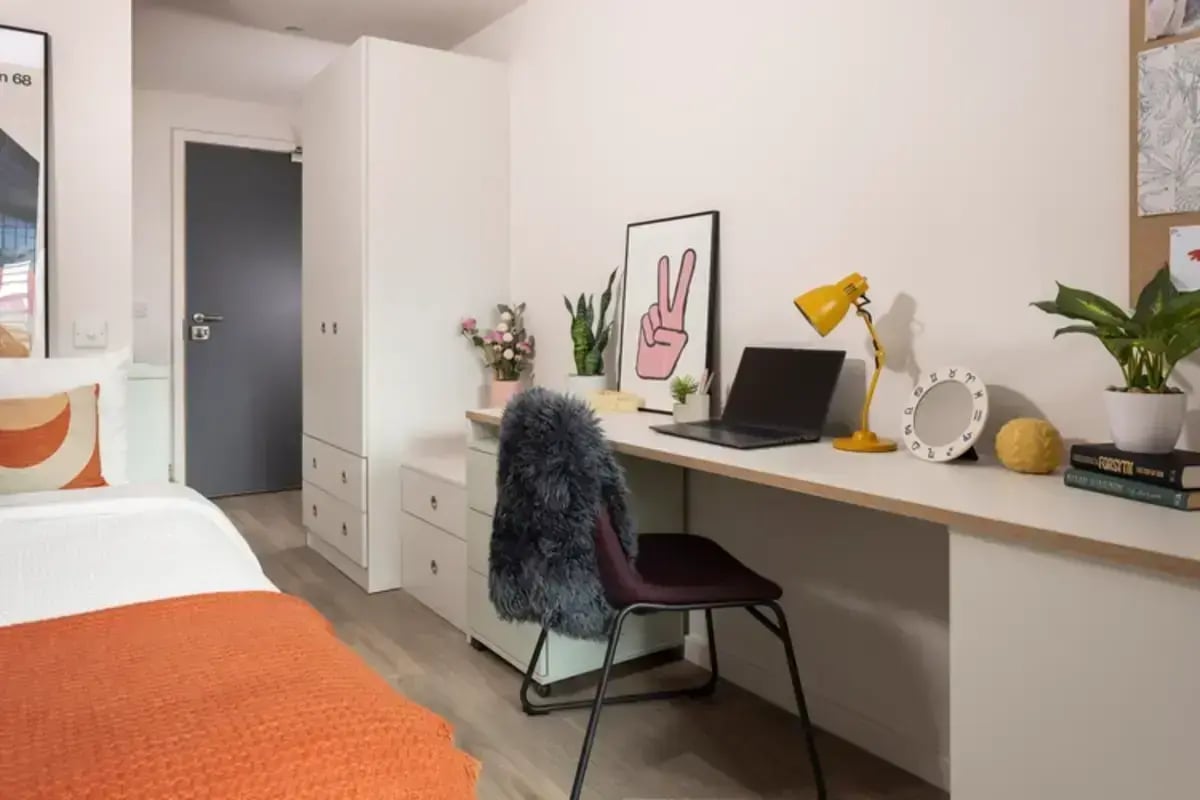 Desk with laptop plants and decor bedroom at Hawthorne House in London Student Accommodation