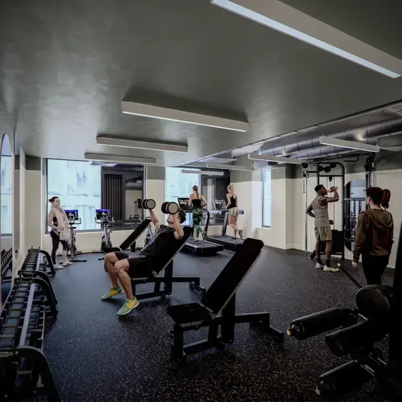 Gym equipment with people exercising fitness room at Hawthorne House in London Student Accommodation