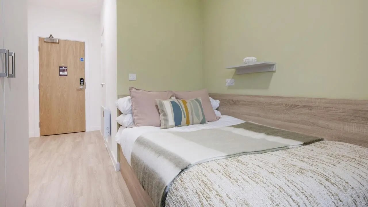 Bed with pillows blankets and a shelf Bedroom at St Gabriels in Manchester Student Accommodation
