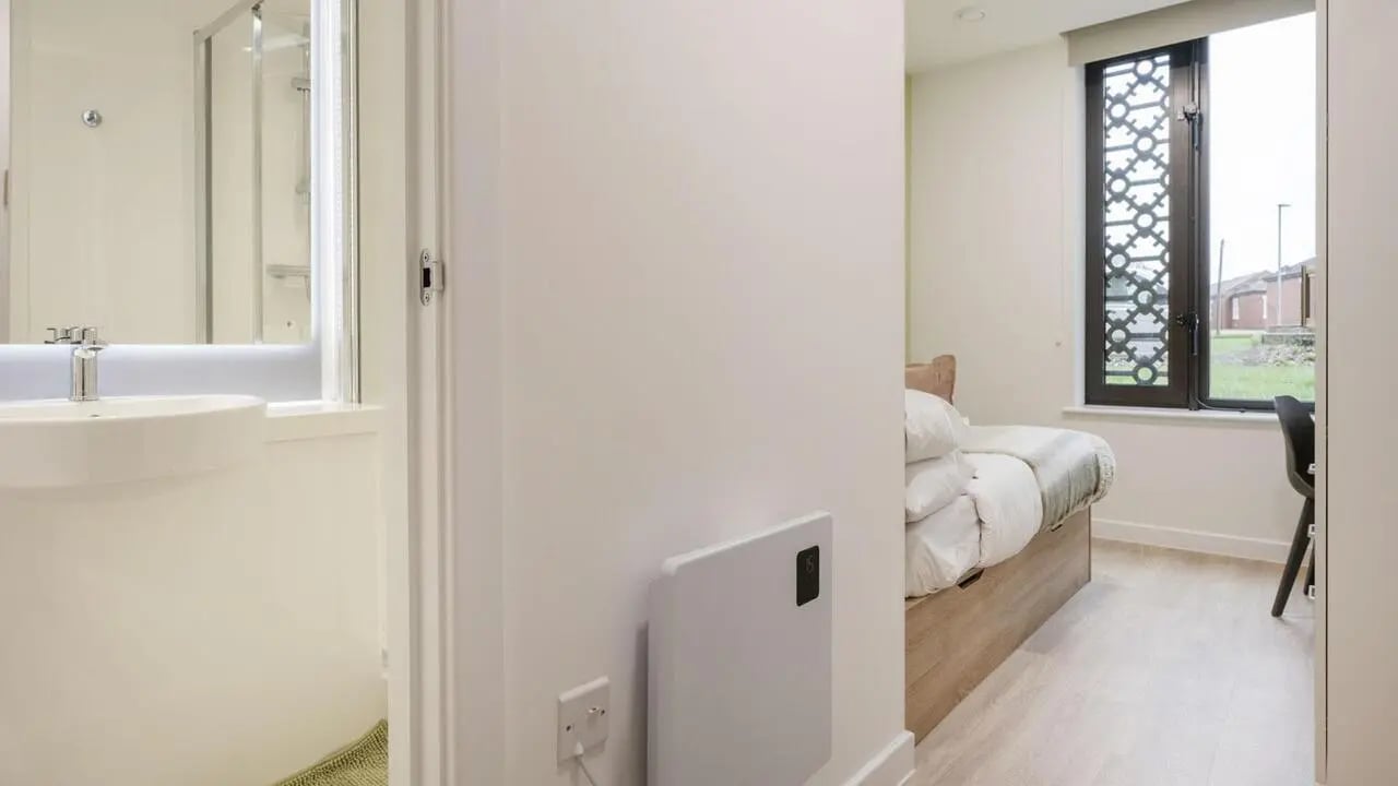Bed with white linens and desk area bedroom at St Gabriels in Manchester Student Accommodation