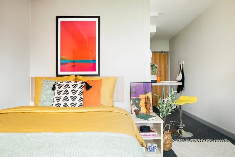 Bed with art and yellow stool bedroom at Blackfriars in Glasgow Student Accommodation